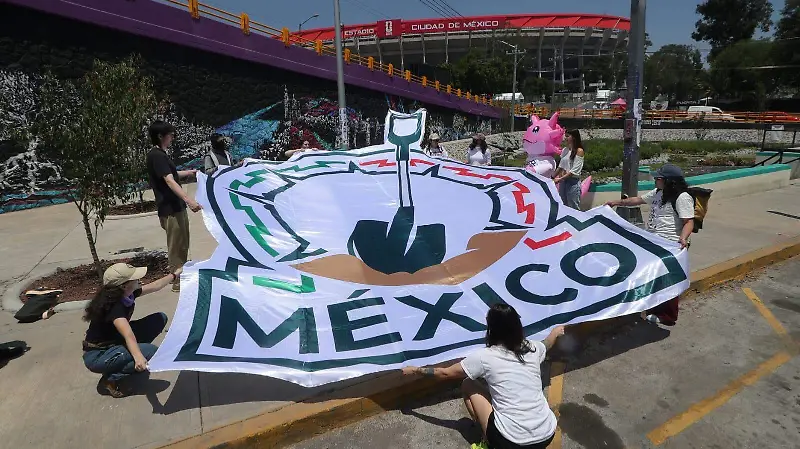 Con un ajolote y una pala “mundialista” familias pegan fichas de búsqueda cerca del Estadio Azteca